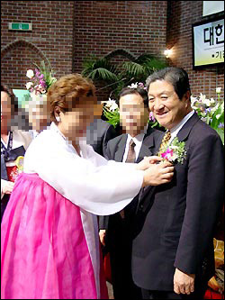 2002년 예장합동 부총회장에 당선된 임 목사에게 여성 신도가 꽃을 달아주고 있는 모습. 